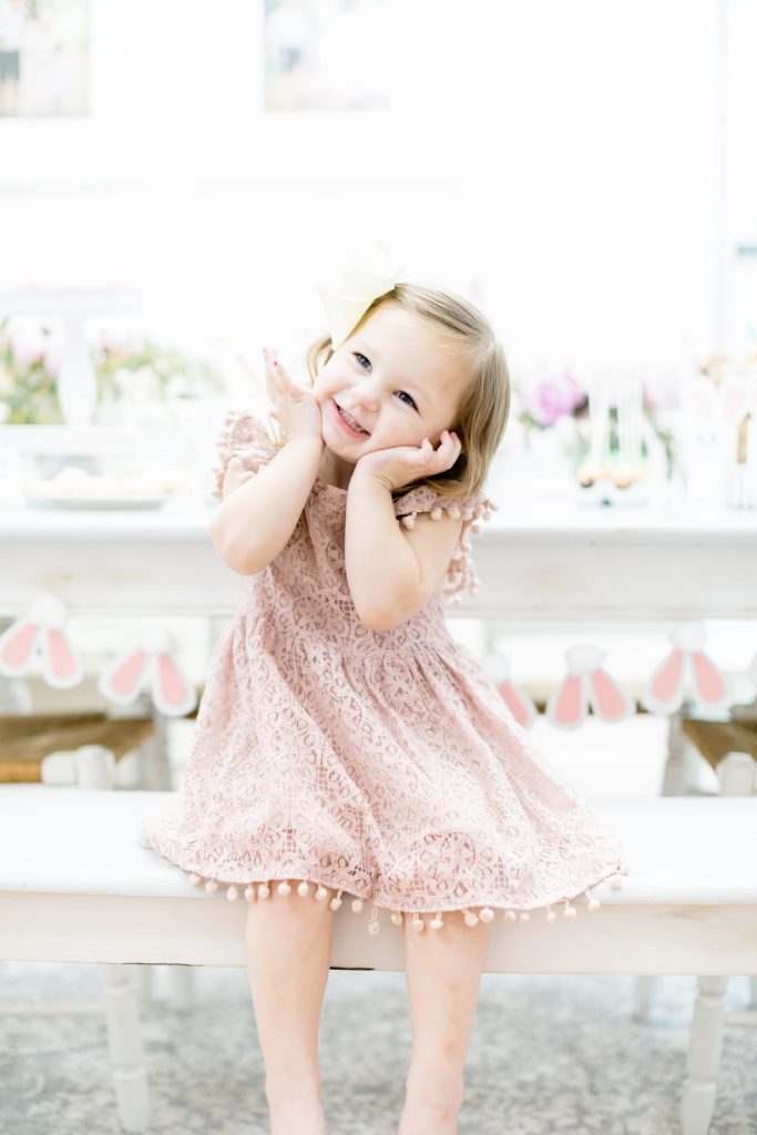 cute girl in pom pom lace blush dress. bunny birthday party 